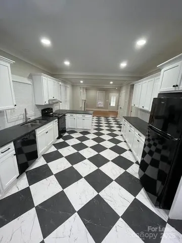 a kitchen with a checkered floor and white cabinets