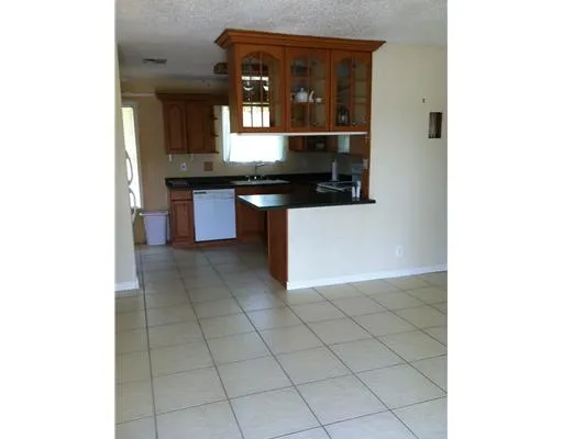 a kitchen with granite countertop a sink and a stove