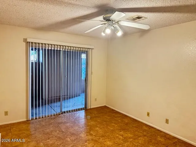 an empty room with a ceiling fan and painted walls