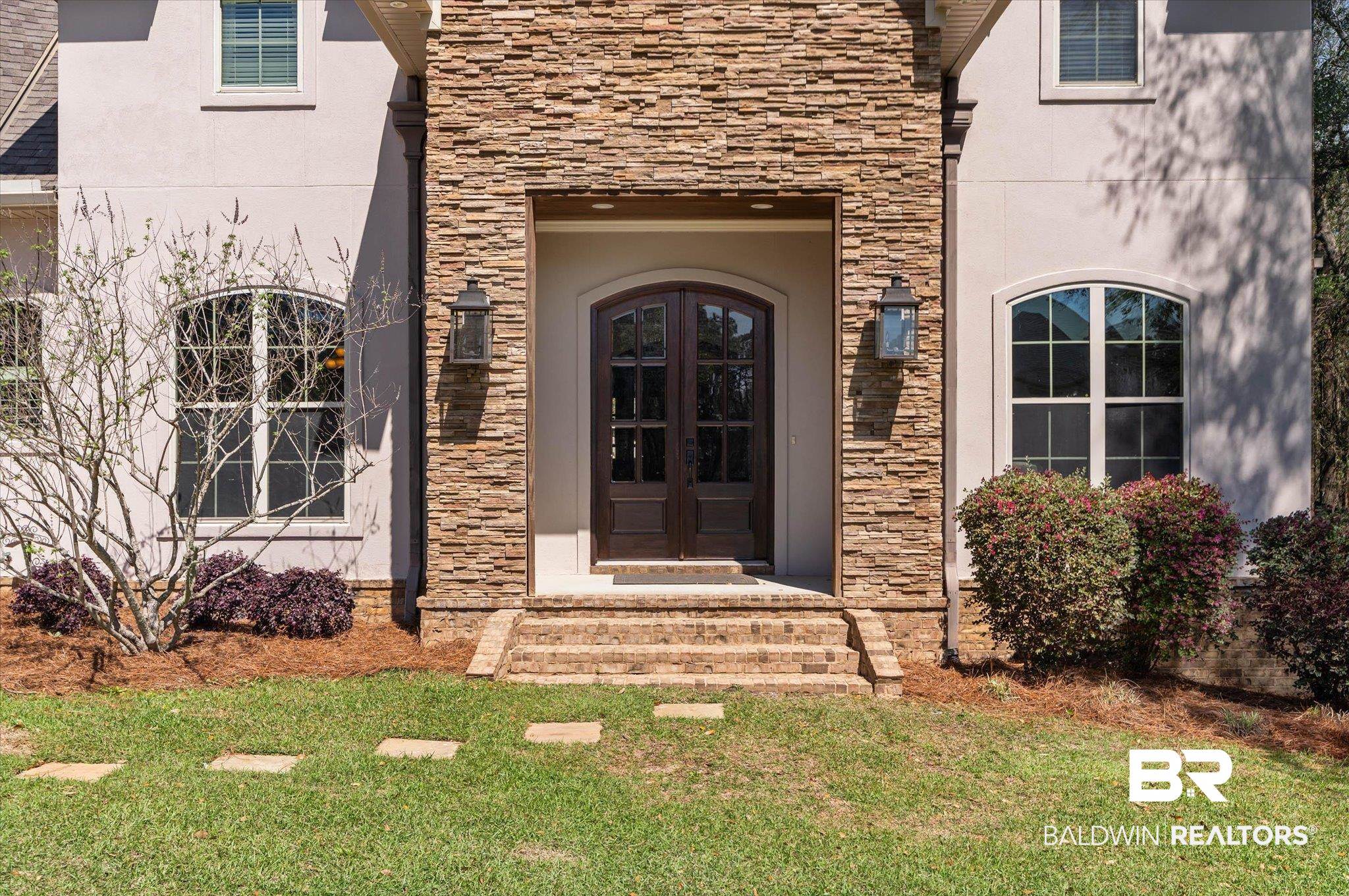 7676 Rockstone Lane Mobile, AL 36695 - Photo 44 of 47 View of exterior entry with french doors, stone siding, stucco siding, and a lawn