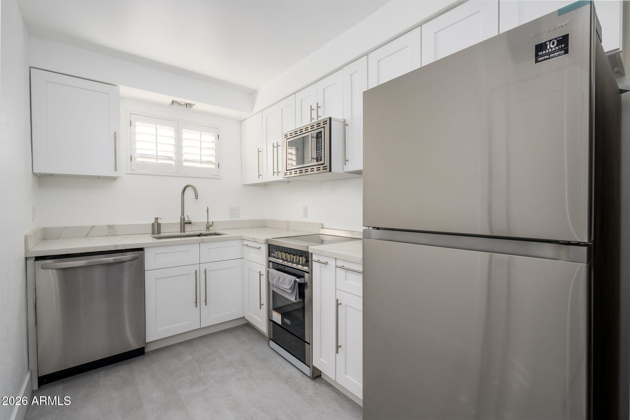 1004 East Osborn Road, Unit B Phoenix, AZ 85014 - Photo 1 of 22 a kitchen with white cabinets and white appliances