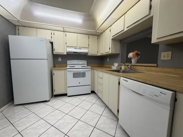 a kitchen with a refrigerator sink stove and cabinets
