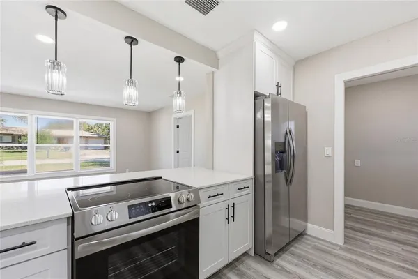 a kitchen with stainless steel appliances a stove a refrigerator and a window