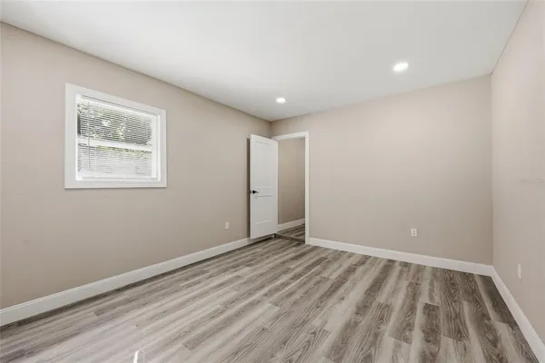 a view of empty room with wooden floor