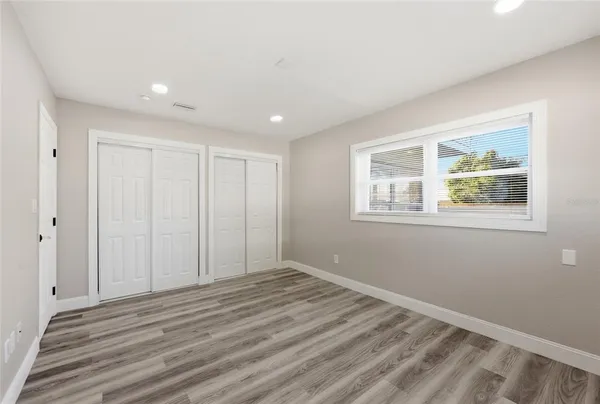 a view of empty room with wooden floor and window