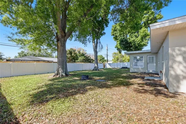 a view of a house with backyard and a tree