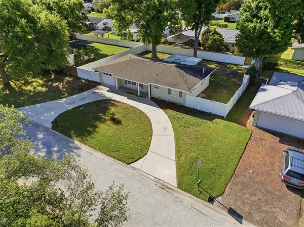 an aerial view of a house with a yard and trees