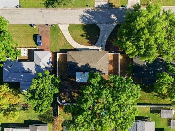 an aerial view of a house with a yard and a large tree