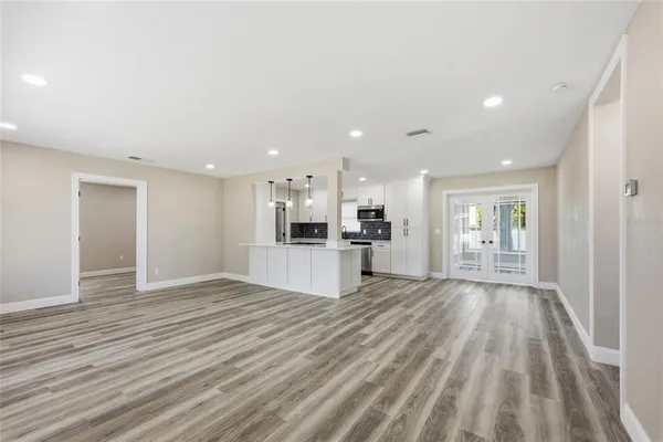 a view of kitchen with kitchen island wooden floor center island and stainless steel appliances