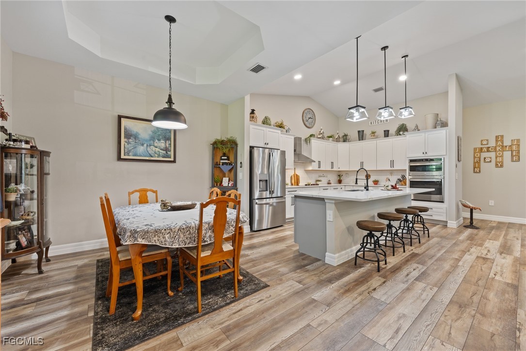 2391 Lippincott Road Alva, FL 33920 - Photo 16 of 50 a dining room filled chandelier and wooden floor