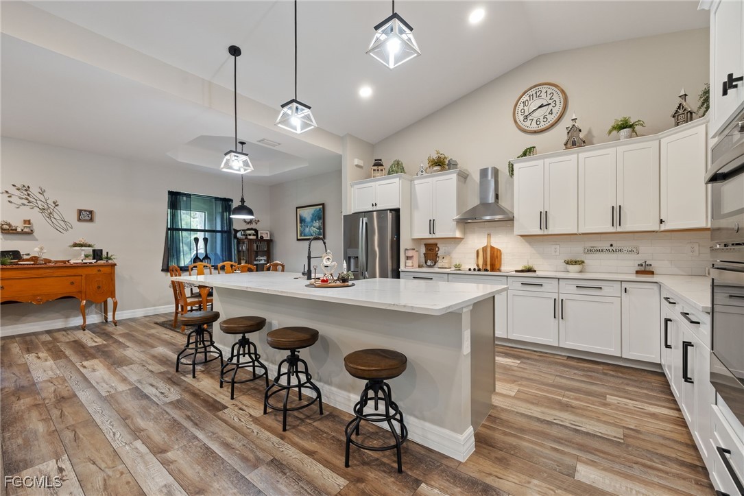 2391 Lippincott Road Alva, FL 33920 - Photo 20 of 50 a open kitchen with stainless steel appliances granite countertop a sink a stove and chairs with wooden floor