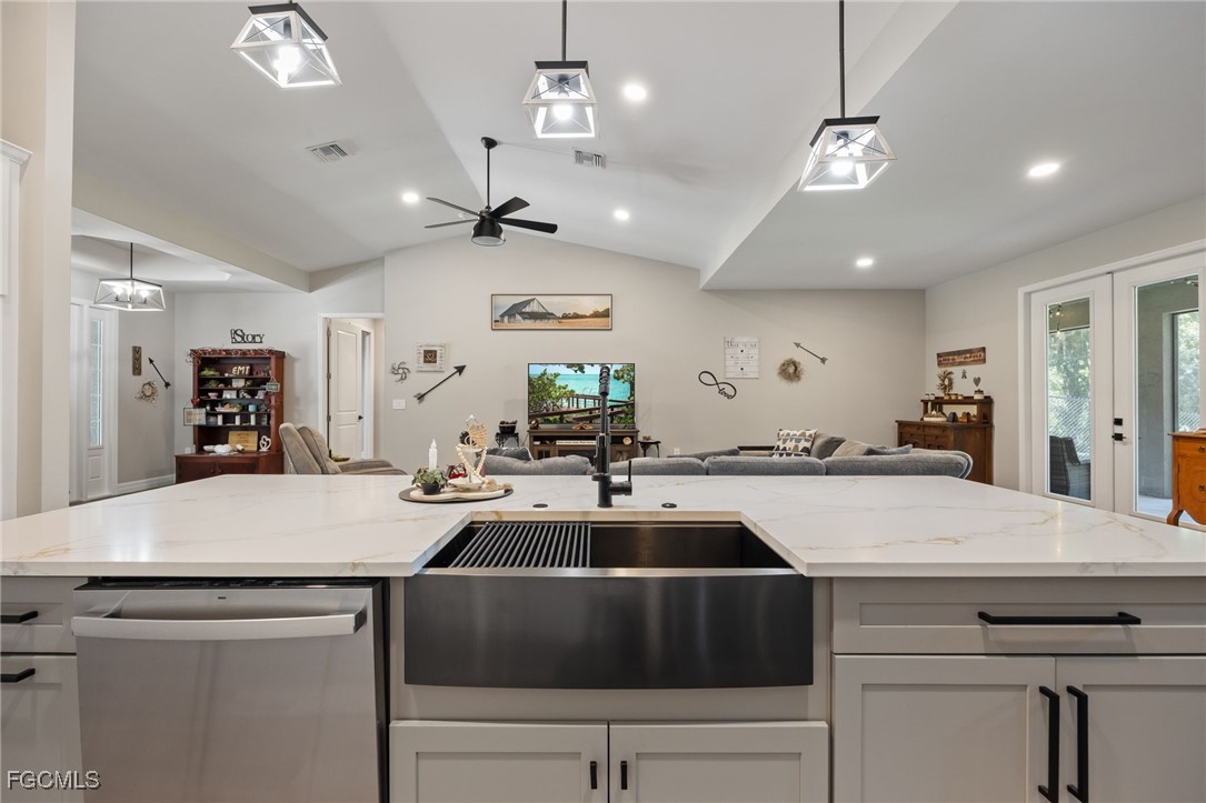 2391 Lippincott Road Alva, FL 33920 - Photo 22 of 50 a kitchen with kitchen island a stove a counter space a sink and living room view
