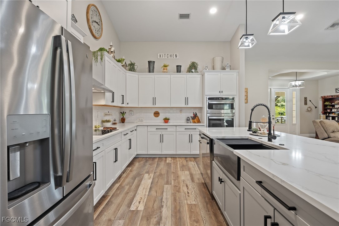 2391 Lippincott Road Alva, FL 33920 - Photo 23 of 50 a kitchen with kitchen island granite countertop a sink appliances cabinets and a counter top space