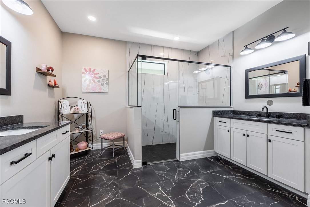 2391 Lippincott Road Alva, FL 33920 - Photo 26 of 50 a spacious bathroom with a granite countertop sink a toilet a shower and a mirror