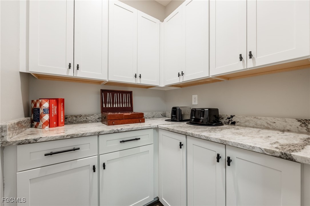 2391 Lippincott Road Alva, FL 33920 - Photo 37 of 50 a kitchen with granite countertop white cabinets and white appliances