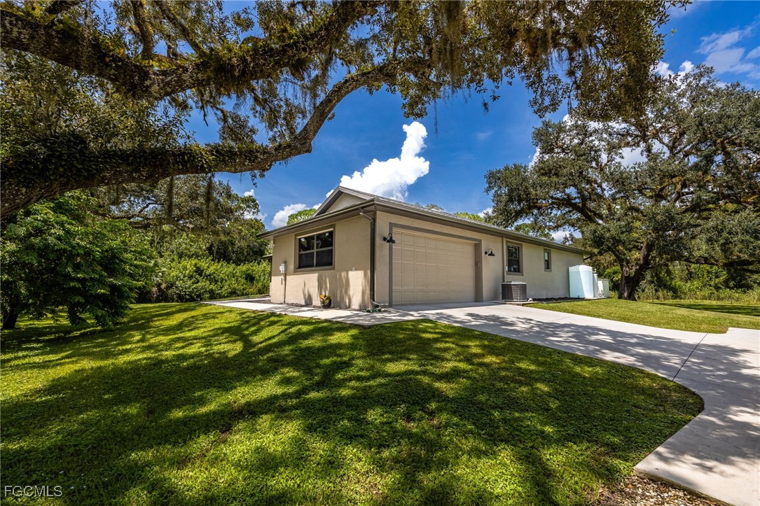 2391 Lippincott Road Alva, FL 33920 - Photo 43 of 50 a front view of a house with a yard and garage