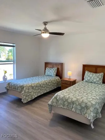 a bedroom with two beds and a chandelier