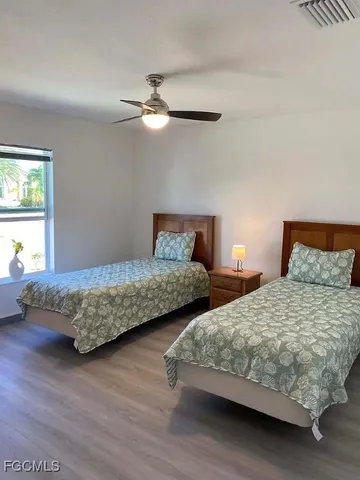 a bedroom with two beds and a chandelier