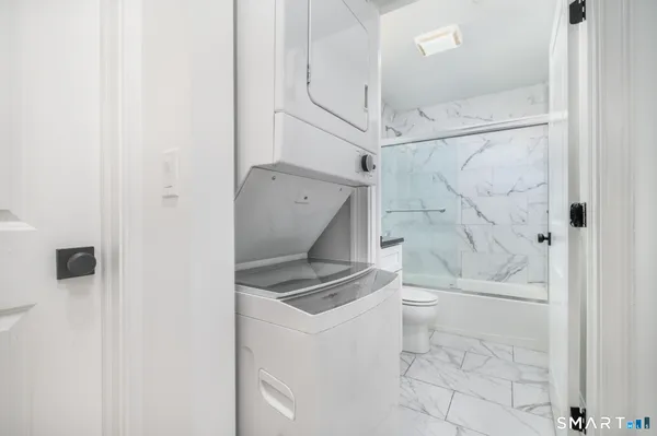 a bathroom with a granite countertop sink a toilet and shower