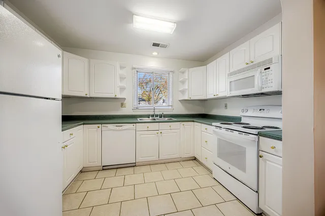 a kitchen with stainless steel appliances granite countertop a sink and a stove