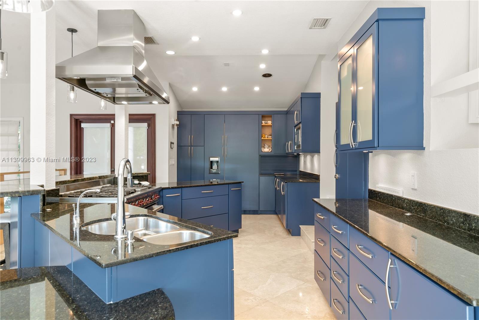 12521 Ramiro Street Coral Gables, FL 33156 - Photo 11 of 53 a kitchen with kitchen island granite countertop a sink stove and cabinets