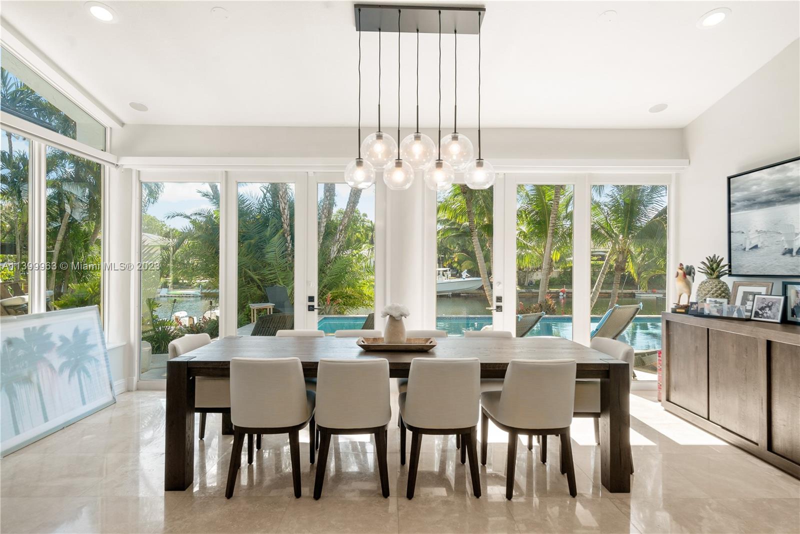 12521 Ramiro Street Coral Gables, FL 33156 - Photo 16 of 53 a view of a dining room with furniture large windows and wooden floor