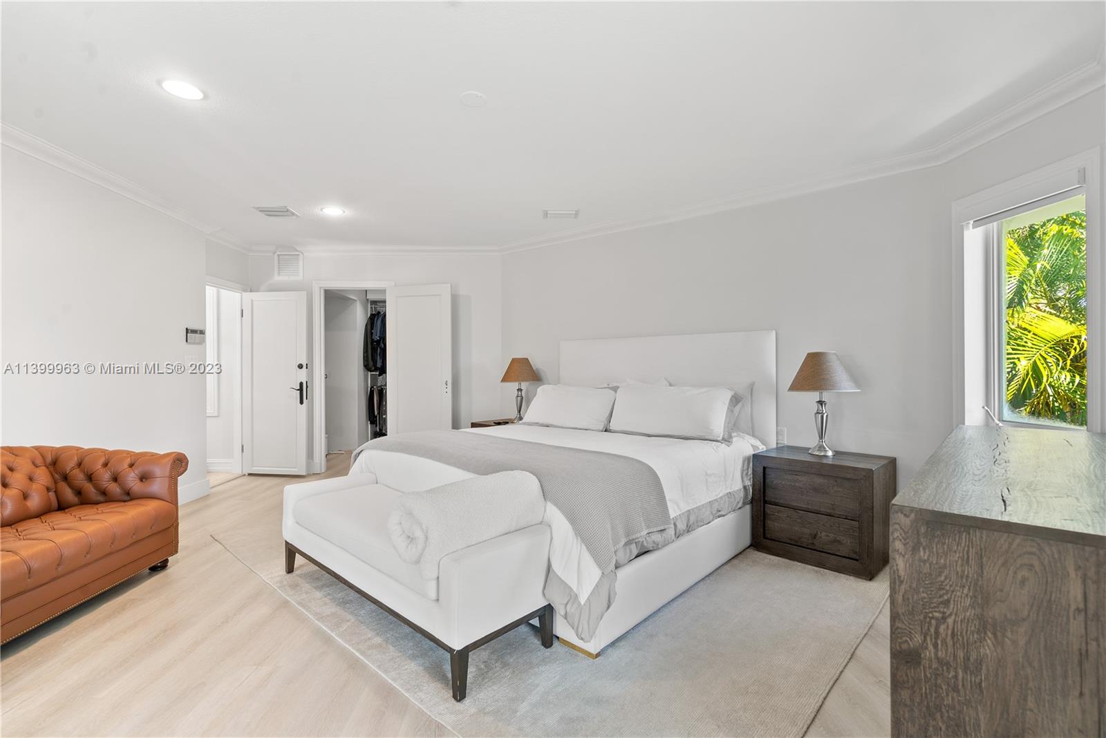 12521 Ramiro Street Coral Gables, FL 33156 - Photo 19 of 53 a spacious bedroom with a bed and a couch