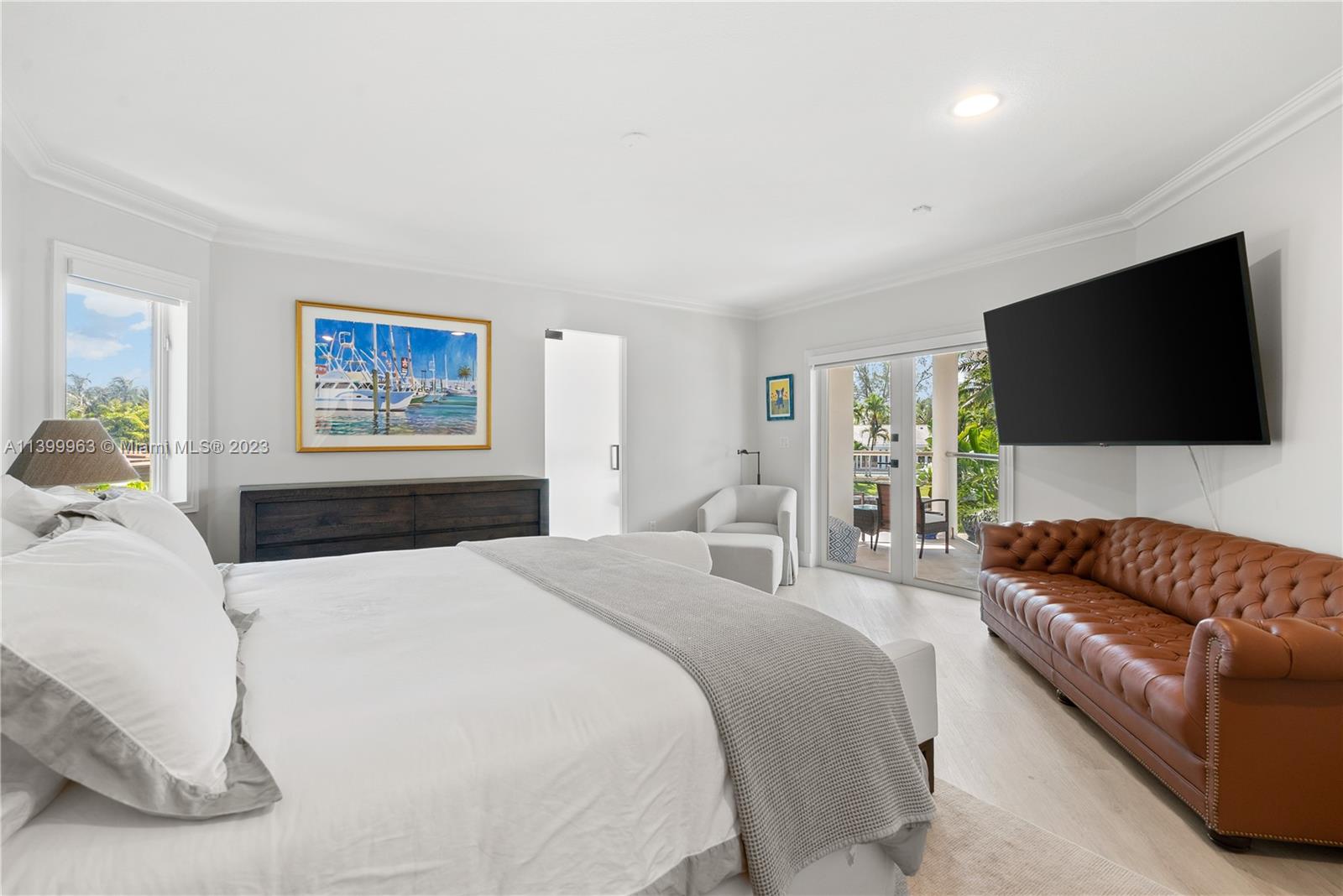 12521 Ramiro Street Coral Gables, FL 33156 - Photo 20 of 53 a bedroom with a bed a couch and a flat screen tv