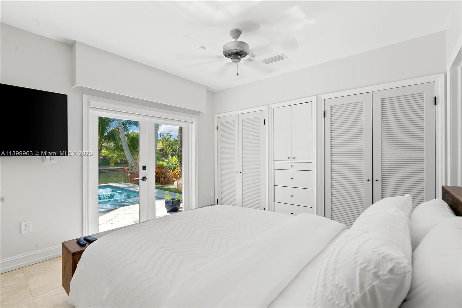 12521 Ramiro Street Coral Gables, FL 33156 - Photo 27 of 53 a bedroom with a large bed and a flat tv screen on dresser