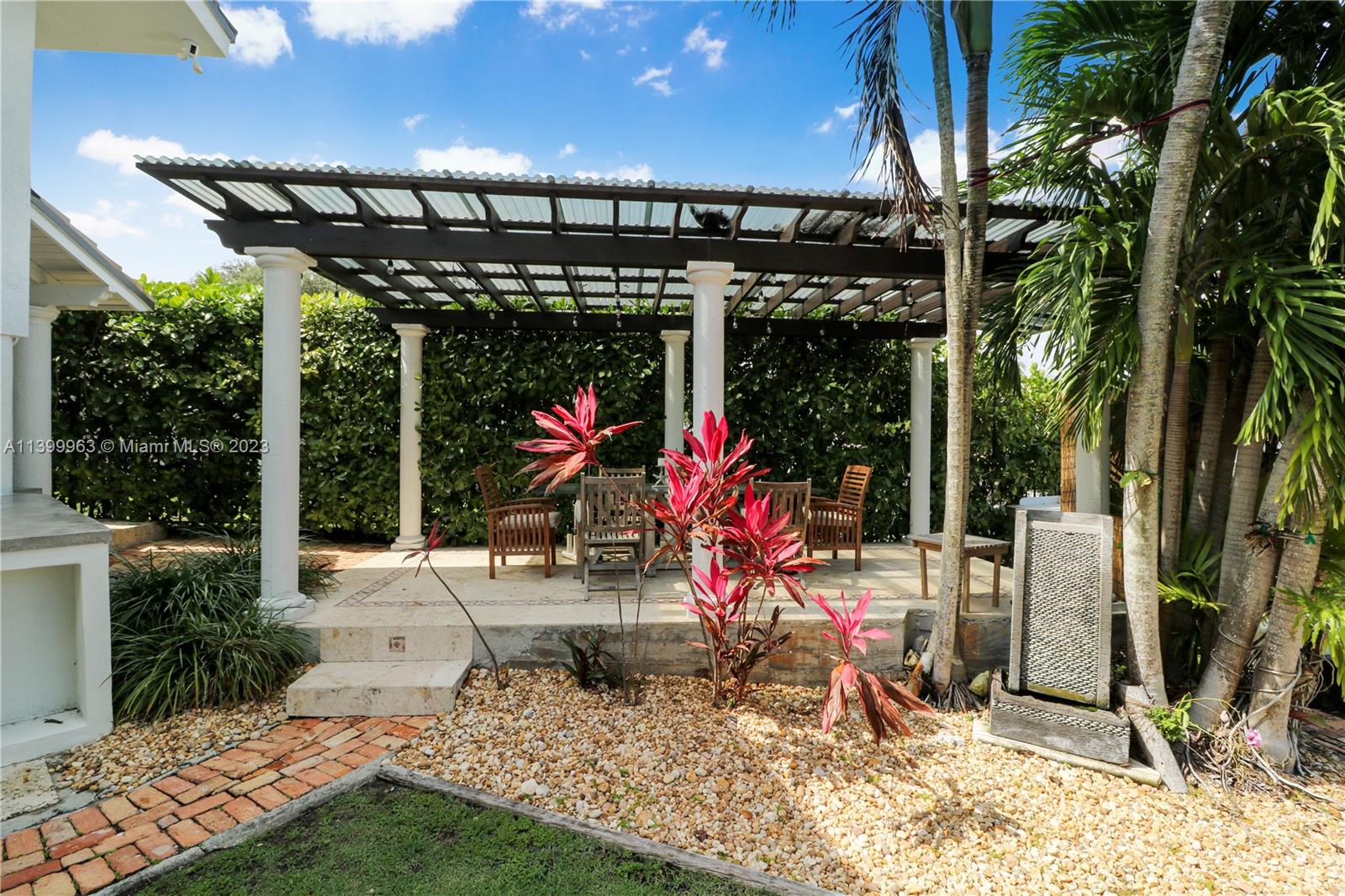 12521 Ramiro Street Coral Gables, FL 33156 - Photo 33 of 53 a view of a patio with a table and chairs under an umbrella
