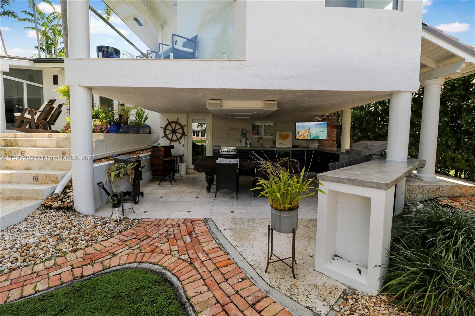 12521 Ramiro Street Coral Gables, FL 33156 - Photo 44 of 53 a view of a patio with table and chairs potted plants with wooden fence