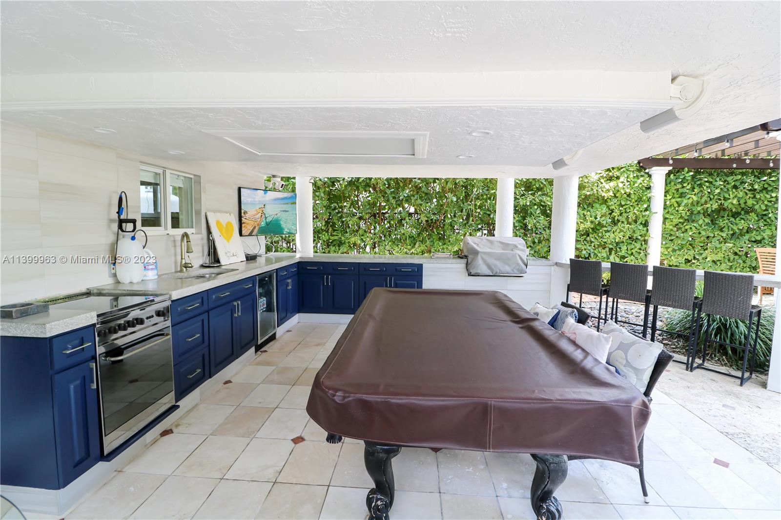 12521 Ramiro Street Coral Gables, FL 33156 - Photo 45 of 53 a kitchen with a table chairs and wooden cabinets