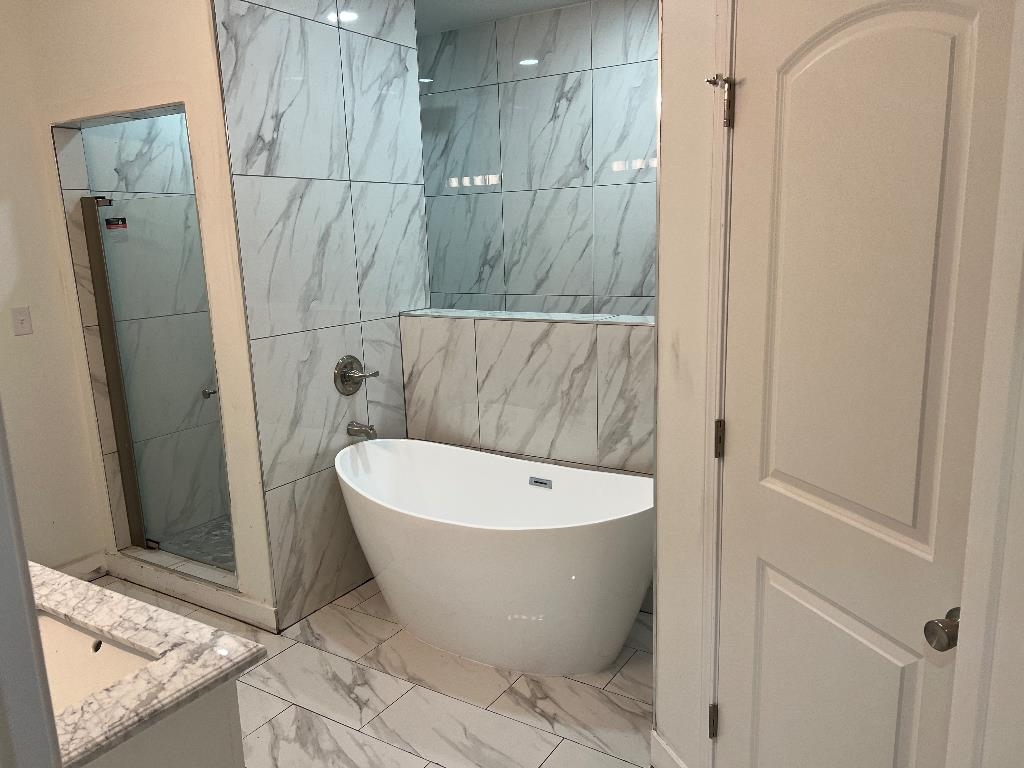 4566 Independent Road Bartlett, TN 38002 - Photo 14 of 23 Full bathroom featuring marble look tiles, vanity, a freestanding bath, a shower stall, and tile walls