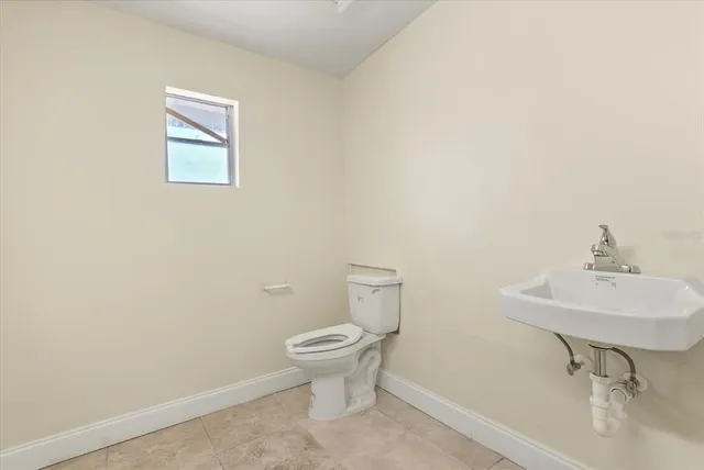 a bathroom with a sink toilet and a mirror