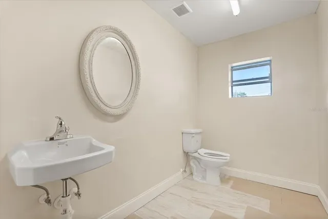 a bathroom with a toilet a sink and a mirror