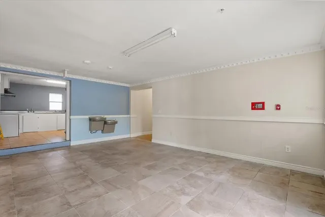 an empty room with windows and fireplace