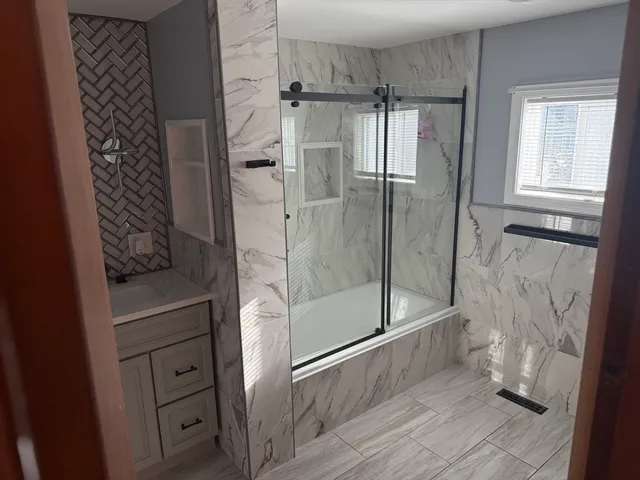 a bathroom with a glass shower door and a sink
