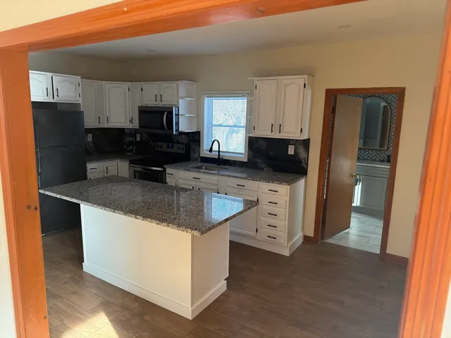 a kitchen with stainless steel appliances granite countertop a refrigerator stove microwave and sink