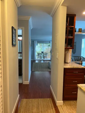 a view of a hallway with wooden floor and staircase