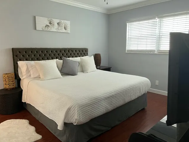 a large bed sitting in a bedroom next to a window