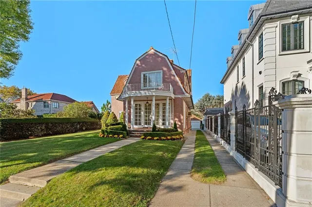 a view of a big yard in front of a brick house with a small yard