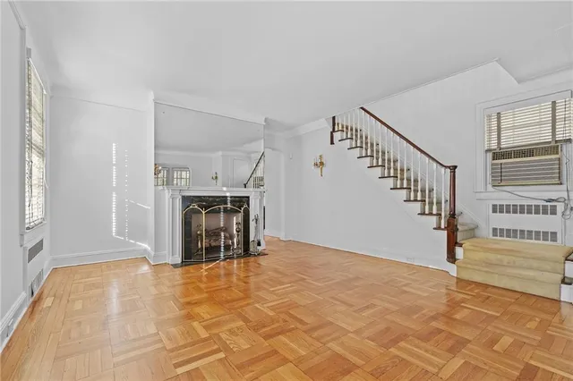 a view of a livingroom with wooden floor and a kitchen