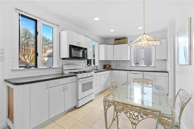 a kitchen with stainless steel appliances granite countertop a stove a sink and a microwave