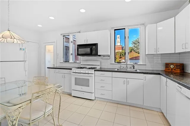 a kitchen with white cabinets and appliances