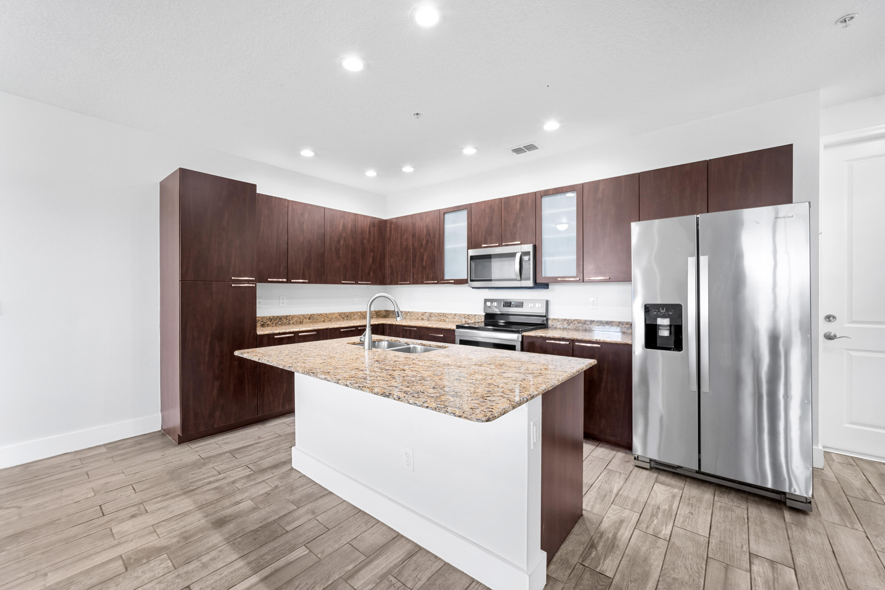 1430 Northwest 48th Lane Boca Raton, FL 33431 - Photo 6 of 54 a kitchen with a refrigerator a sink and wooden floor