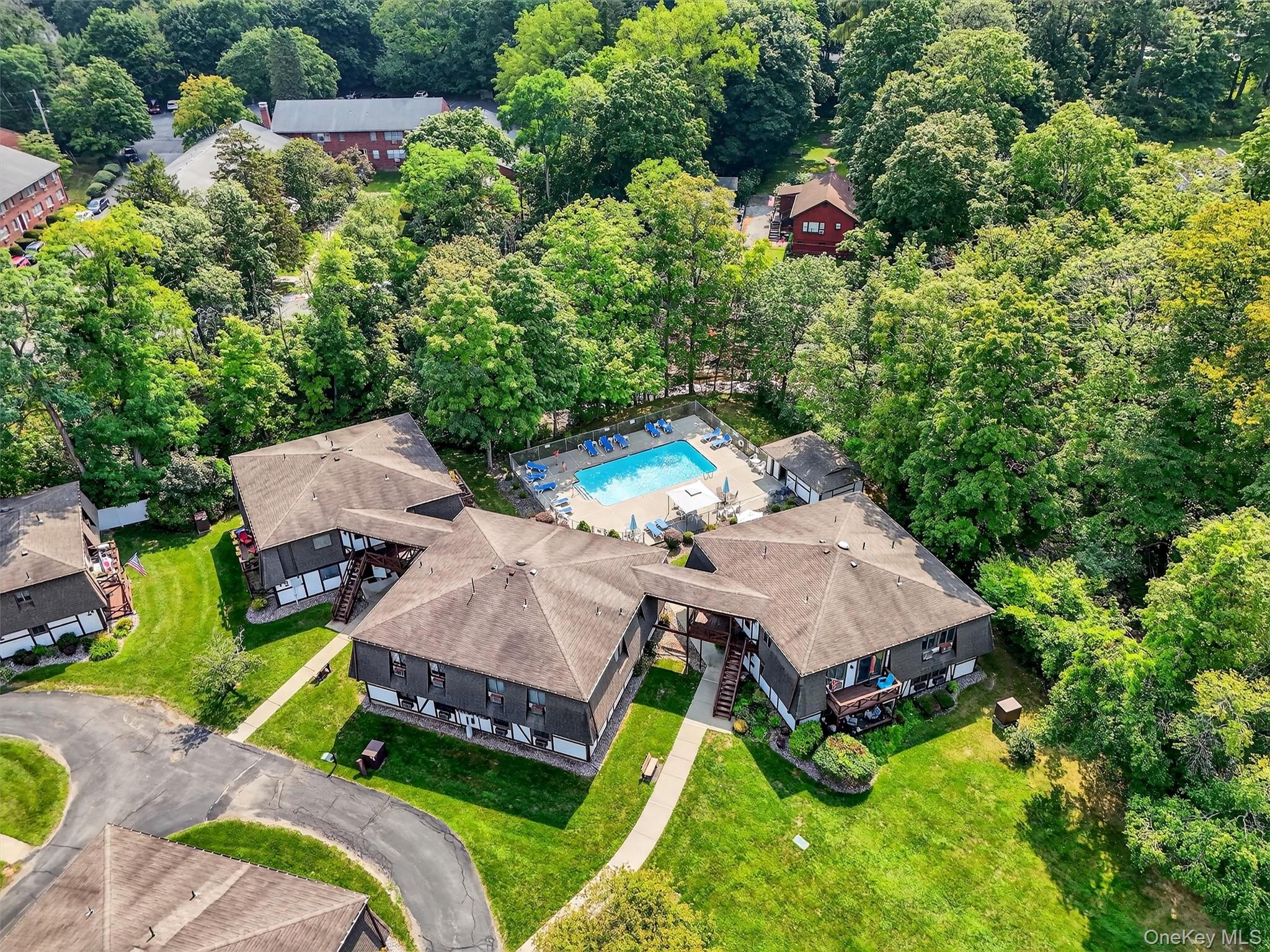 an aerial view of a house with swimming pool and garden