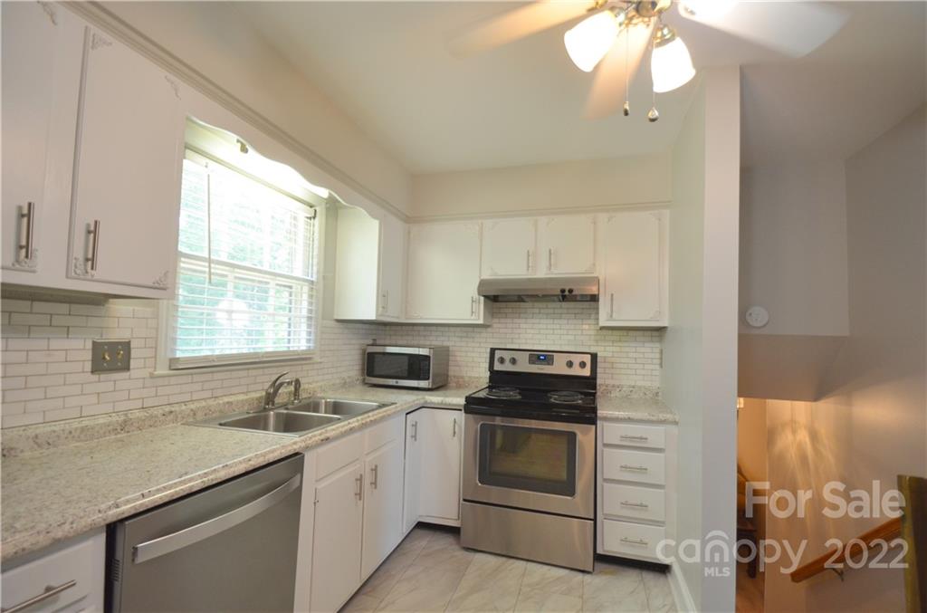 7433 Riding Trail Road Charlotte, NC 28212 - Photo 16 of 42 a kitchen with stainless steel appliances a stove sink and cabinets