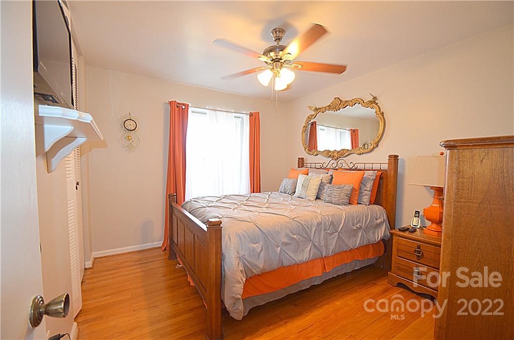 7433 Riding Trail Road Charlotte, NC 28212 - Photo 21 of 42 a bedroom with a bed and a chandelier