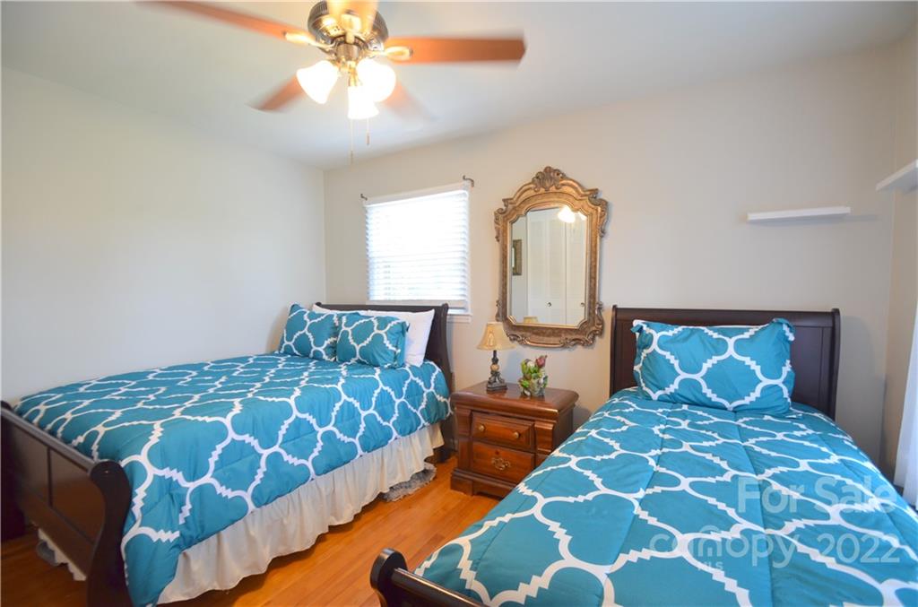 7433 Riding Trail Road Charlotte, NC 28212 - Photo 25 of 42 a bedroom with a bed and a chandelier