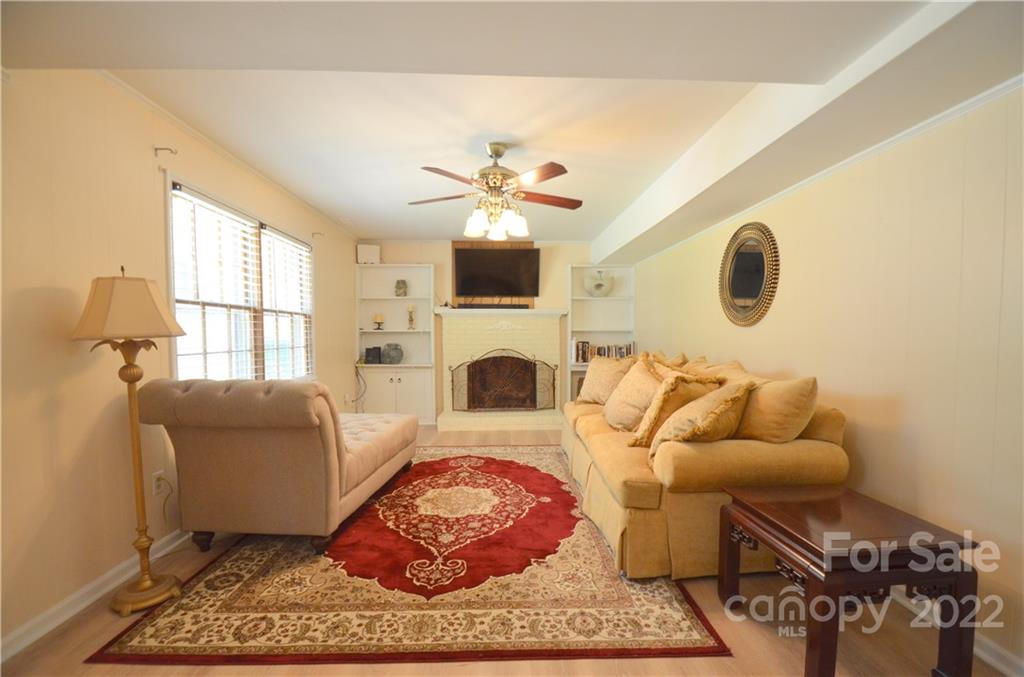 7433 Riding Trail Road Charlotte, NC 28212 - Photo 27 of 42 a living room with furniture a fireplace and a flat screen tv